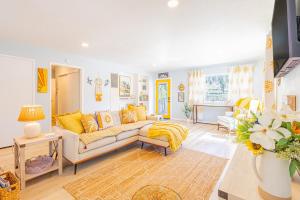 a living room with a couch and yellow pillows at Sunshine Loft in Wrightwood