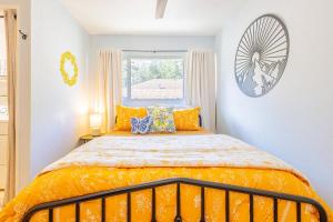 a bedroom with a bed with orange sheets and a window at Sunshine Loft in Wrightwood