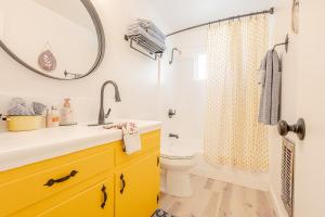 a bathroom with a sink and a toilet and a mirror at Sunshine Loft in Wrightwood +80 photos