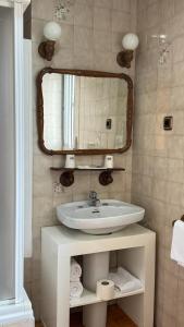 a bathroom with a sink and a mirror at Hosteria Conchi in Madrigal de la Vera