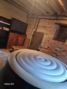 a large white sink in a room with a brick wall at Ancienne étable in Pierrefitte-sur-Sauldre