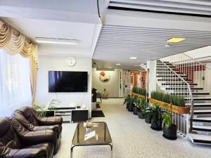 a living room with couches and a tv and stairs at Hotel Ilomantsi North Star in Ilomantsi
