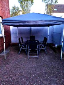 a blue tent with chairs and a table under it at NEU Monteurhaus und Ferienhaus 5 Betten Parkplatz 24h Checkin in Alsdorf
