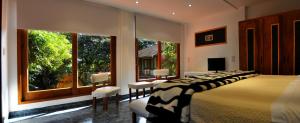 a bedroom with a bed with chairs and a large window at La Locanda Art & Taste Retreat in Puerto Iguazú