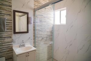 a bathroom with a sink and a glass shower at Santa Elena 400 in Torreón +34 photos