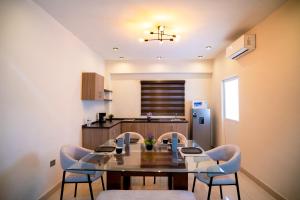 a dining room with a table and chairs and a kitchen at Santa Elena 400 in Torreón