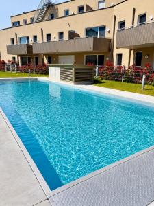 a large blue swimming pool in front of a building at Seelavie in Podersdorf am See
