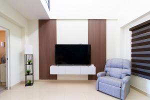 a living room with a tv and a chair at Santa Elena 400 in Torreón