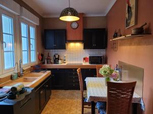 a kitchen with black cabinets and a table and a sink at Le Clos Verdonnais in Verdon +32 photos