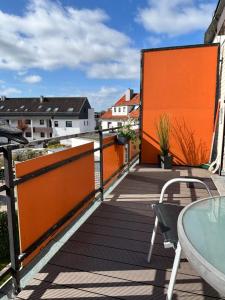a balcony with an orange wall and a table at MeerZeit in Dahme