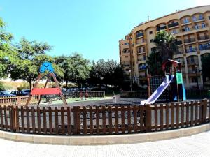 two slides in a playground in front of a building at Premium Oceanside Apartment, Pool, Parking in Port Saplaya