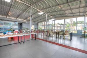 a large room with tables and chairs and windows at Treebo Kuber Palace with Swimming Pool in Mahabaleshwar