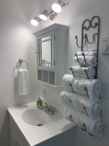 a bathroom with a sink and a stack of towels at Riverfront Studios Inn in Sault Ste. Marie