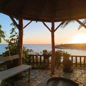 a bench sitting under a gazebo overlooking the ocean at Dionisis Apartments in Kounopetra