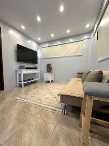 a living room with a couch and a flat screen tv at Evergreen Private Pool Villa - Cavite in General Trias