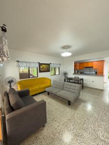 a living room with two couches and a yellow couch at Brisa del Rio Jimenoa in Jarabacoa