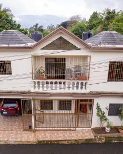 a large white house with a balcony at Brisa del Rio Jimenoa in Jarabacoa +5 photos