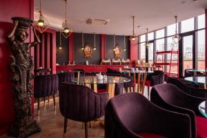 a restaurant with red walls and tables and chairs at Denis Hotel Tbilisi in Tbilisi City
