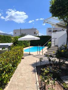a patio with an umbrella next to a swimming pool at Villa Flash in Eantio