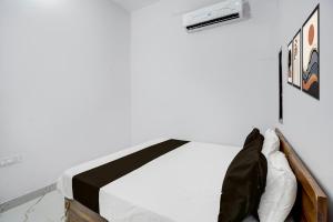 a bedroom with a bed with a black and white blanket at HOTEL O VIP HILL HOMESTAY in Mājra