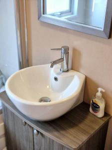 a white sink in a bathroom under a mirror at Birchington Vale - Delta Lodge in Kent +27 photos