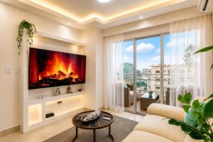 a living room with a fireplace and a large window at Comfy City Center 1BR Condo in Los Prados