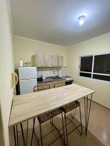 a kitchen with a table with chairs and a refrigerator at Chill Home VIII in Posadas