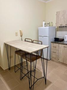 a kitchen with a table and chairs and a white refrigerator at Chill Home VIII in Posadas