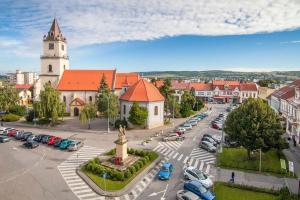 a city with a church and a parking lot with cars at ApartmanONE in Hlohovec +13 photos