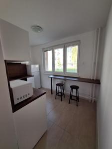 a kitchen with a counter and a table and chairs at ApartmanONE in Hlohovec