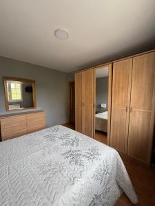 a bedroom with a white bed and wooden cabinets at Casa Mar de Neaño in Neaño