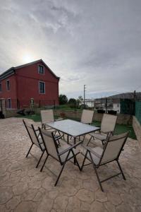 a table and chairs on a patio with a red building at Casa Mar de Neaño in Neaño