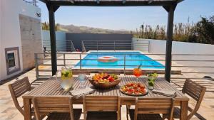 a table with fruit on it next to a pool at Blue Lagoon Villa in Achada