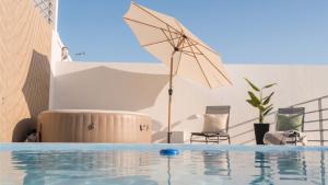 an umbrella sitting next to a swimming pool at Blue Lagoon Villa in Achada
