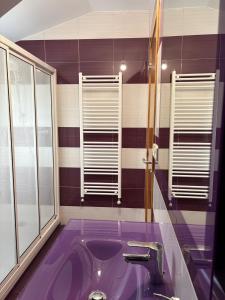 a purple bathroom with a sink and windows at Casa Mar de Neaño in Neaño +40 photos