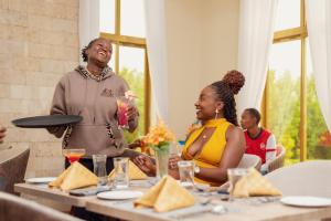 a group of people sitting at a table in a restaurant at WOODSY Resort in Nanyuki +34 photos