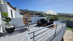 a balcony with a chair and an umbrella at Blue Lagoon Villa in Achada