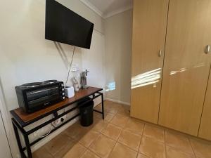 a room with a television and a table with a microwave at Cute Pool Side Apartment in Monte Vista