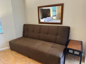 a brown couch in a room with a mirror at Cute Pool Side Apartment in Monte Vista +4 photos