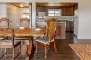 a kitchen with a wooden dining table and chairs at Westlake Consecon Cottage in Wellington +11 photos