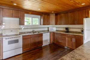a kitchen with wooden cabinets and white appliances at Westlake Consecon Cottage in Wellington