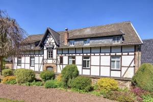 a large white and black house with a yard at Hostel Burg Hausen in Heimbach