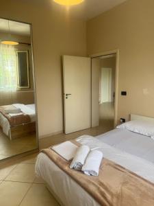 a bedroom with two beds and a mirror at Luna Stay in Vlorë