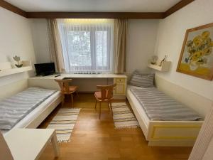 a room with two beds and a desk with a computer at Landhotel Max & Moritz in Liebenau +10 photos