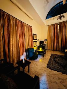 a living room with curtains and a couch and tables at The Regalis Villa in Lucknow