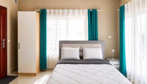 a bedroom with a bed with blue curtains at Milestone Villa in Antananarivo