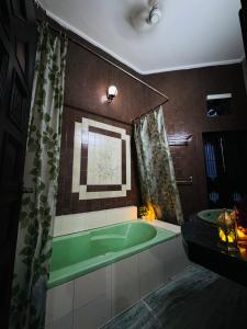 a bathroom with a green tub and a window at The Regalis Villa in Lucknow