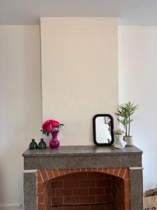 a mirror sitting on top of a brick fireplace at L'Orelia - confortable T2 hyper centre in Montélimar