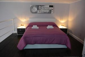 1 dormitorio con 1 cama grande de color púrpura y 2 mesitas de noche en B&B La Torretta Chiaia, en Nápoles