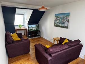 a living room with two couches and a tv at Wonderful Worthing Beach Walk Flat in Worthing